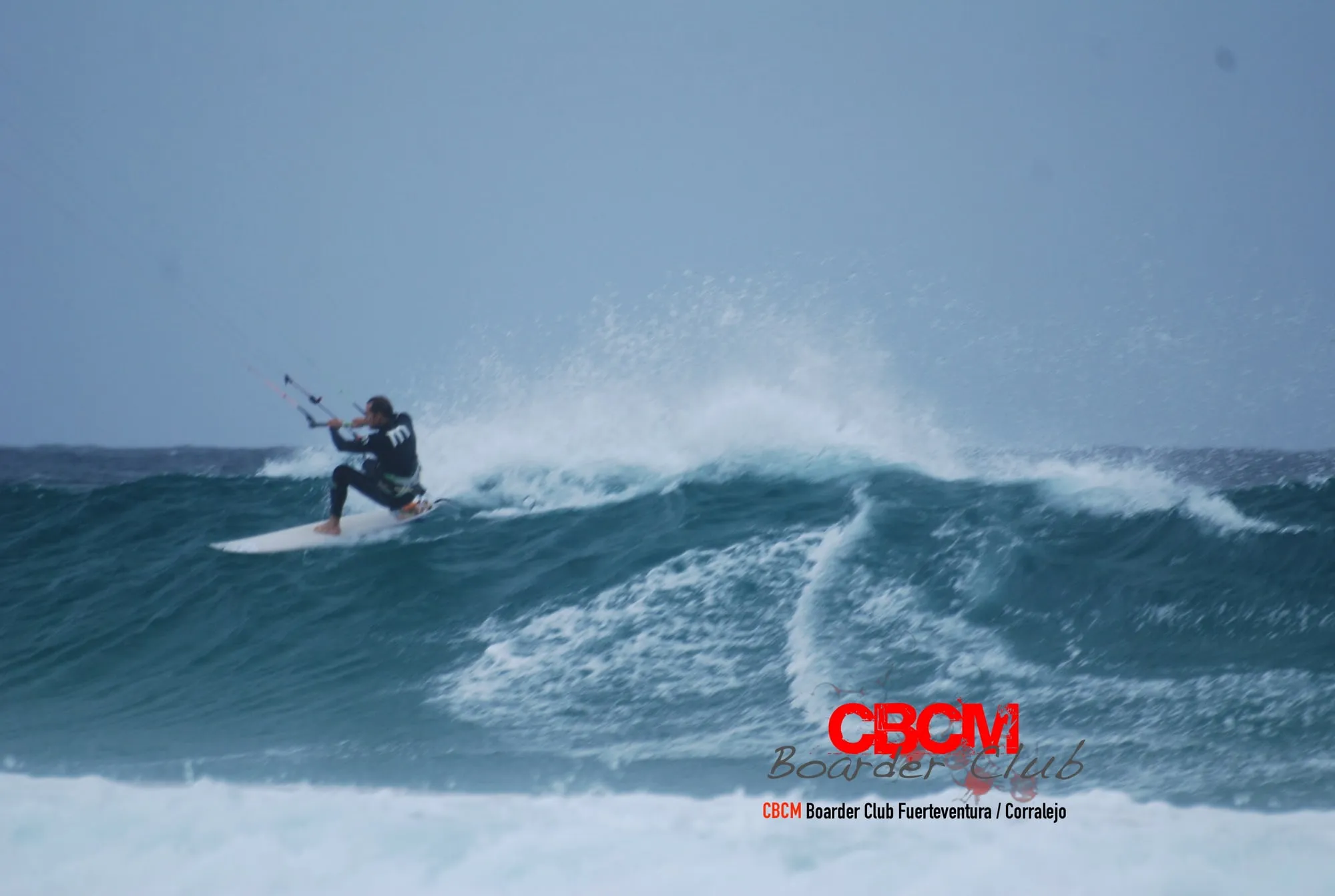 Rider de kitesurf girando sobre una ola grande